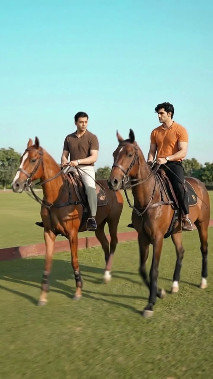 Two men riding horses on a polo field